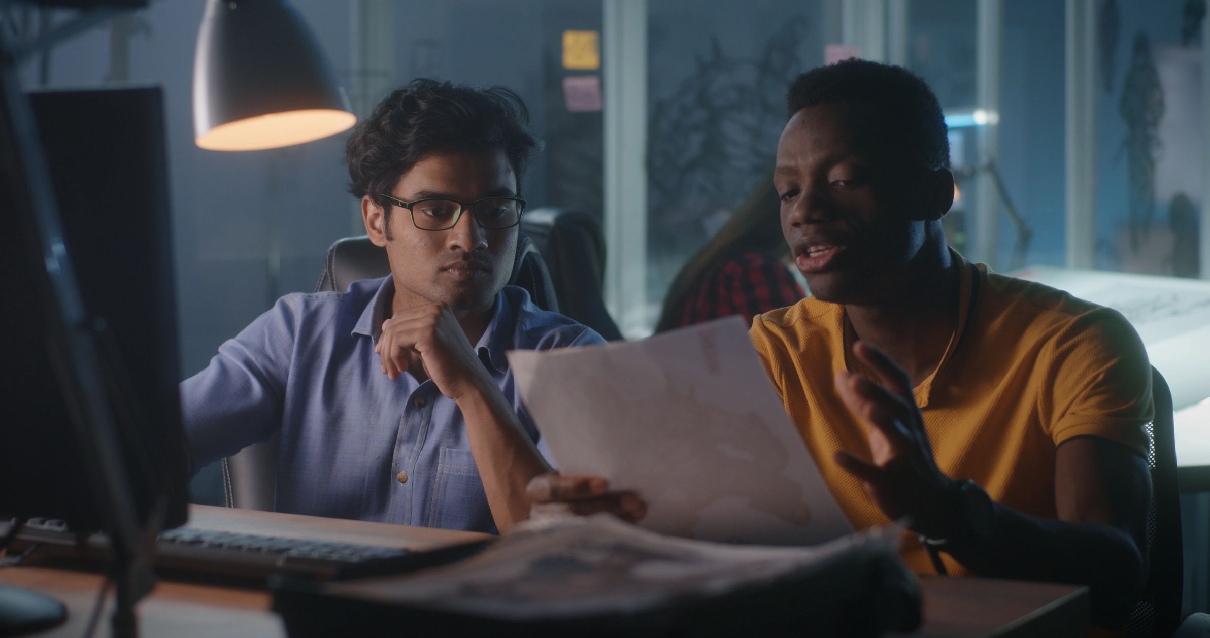 Male and female West African technology professionals reviewing an AI interface together